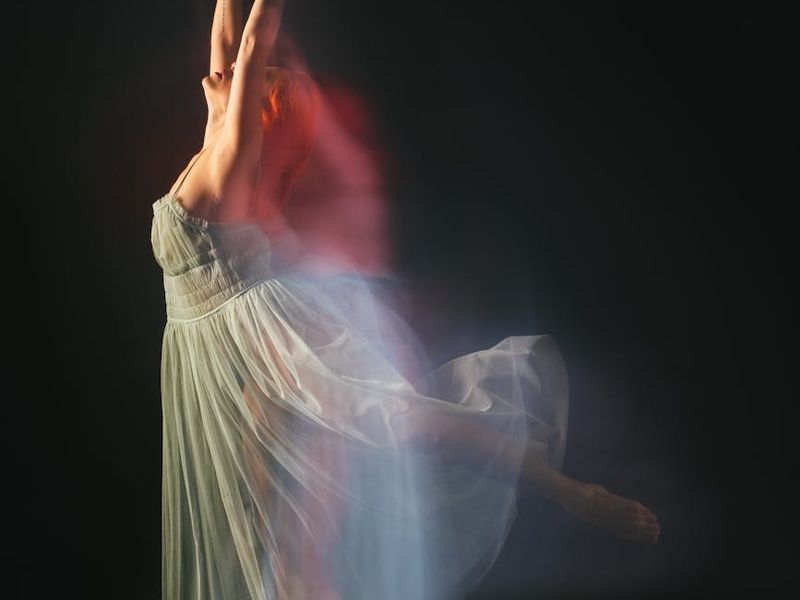 Woman performing a fluid movement on a mat in sunlight